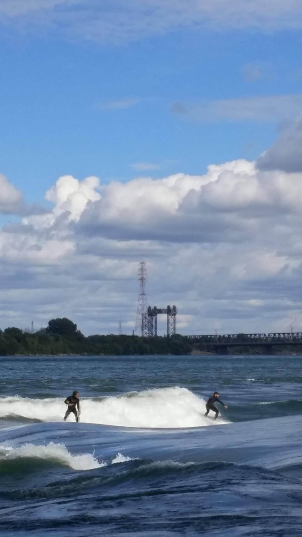 Surfers shredding on the standing wave by Habitat 67