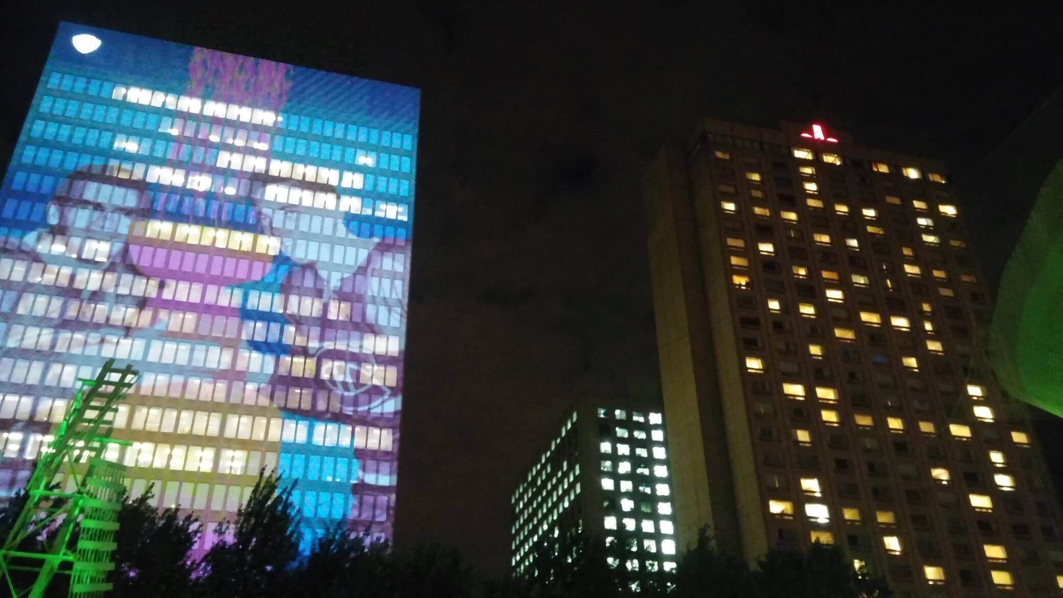 Buildings lit up with trippy advertisements, perfect accompaniment to the music
